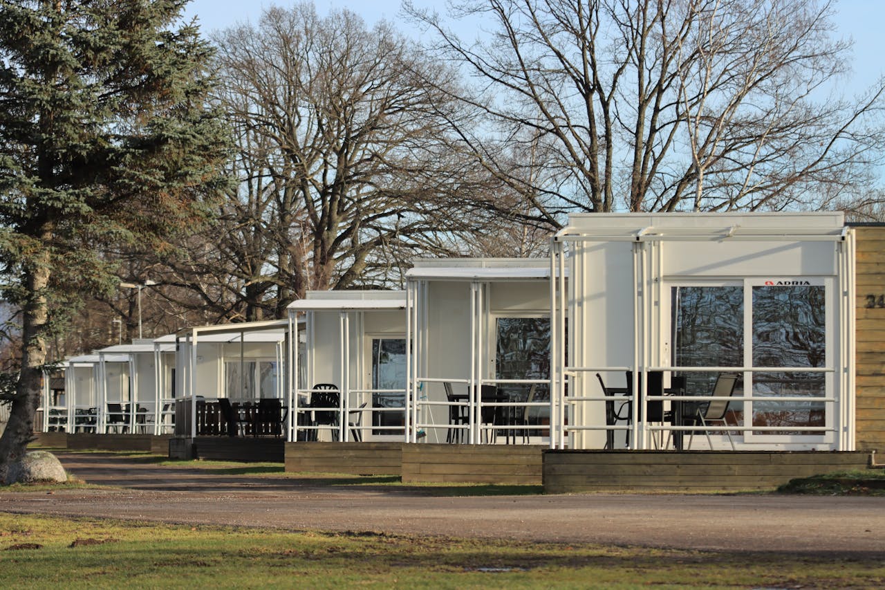 A row of modern holiday cottages in a tranquil forest setting, perfect for a peaceful retreat.